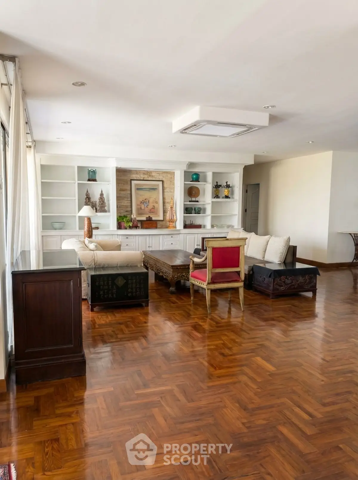 Spacious living room with elegant parquet flooring and stylish furniture