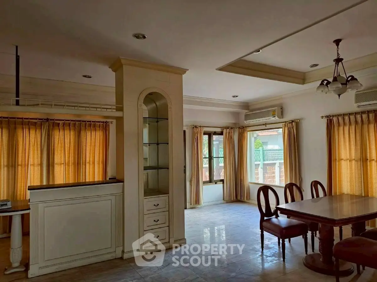 Spacious dining area with elegant wooden furniture and large windows for natural light.