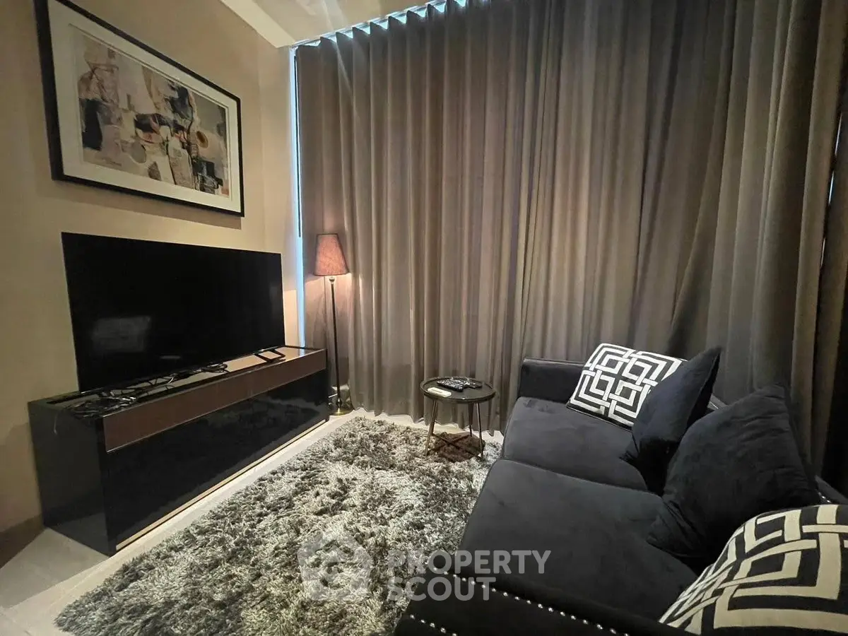Cozy living room with modern decor, plush sofa, and large TV, perfect for relaxation and entertainment.