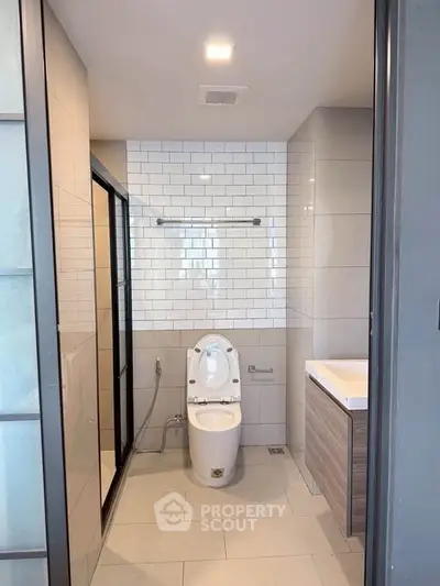 Modern bathroom with sleek design, featuring a glass shower and contemporary fixtures.