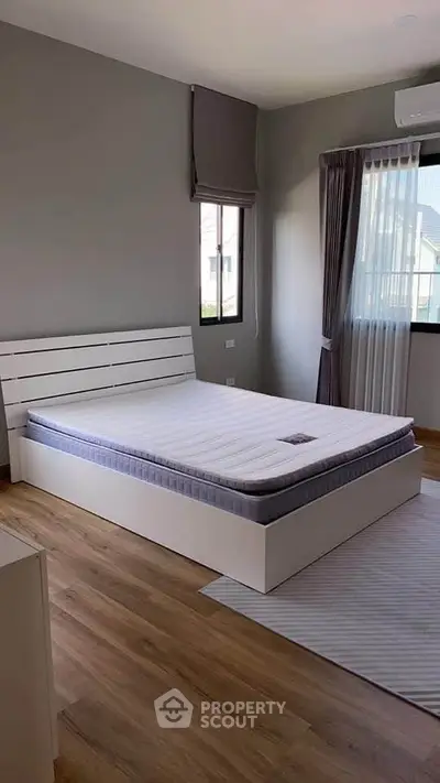 Spacious bedroom with modern design and large windows for natural light.