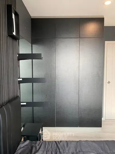 Modern bedroom with sleek black wardrobe and minimalist design