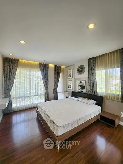 Spacious bedroom with large windows and elegant decor