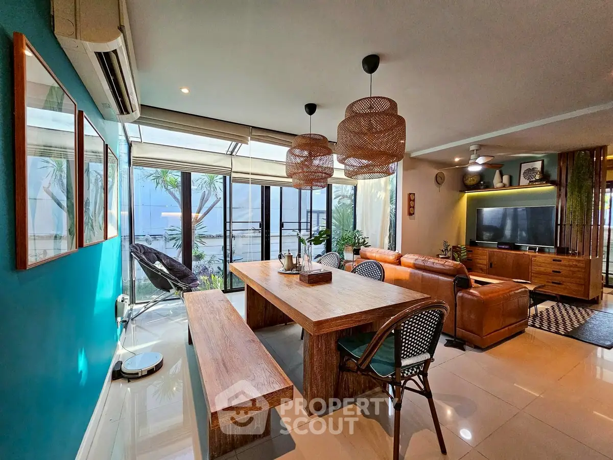 Stylish open-plan living room with modern decor and ample natural light, featuring a cozy seating area and dining space.