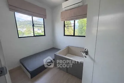 Cozy small bedroom with large windows and air conditioning