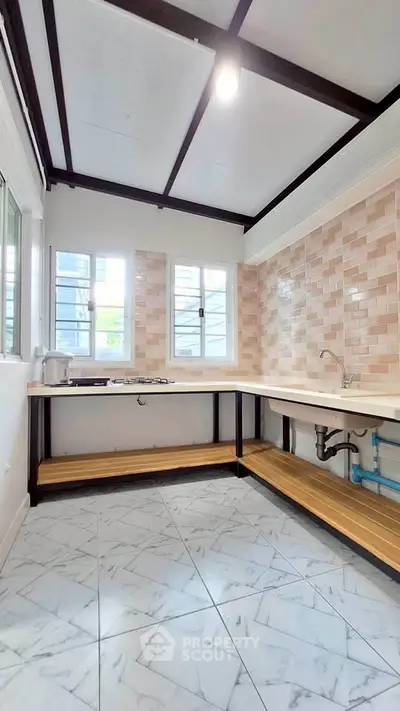 Modern kitchen with open layout and tiled backsplash, featuring a gas stove and ample counter space.