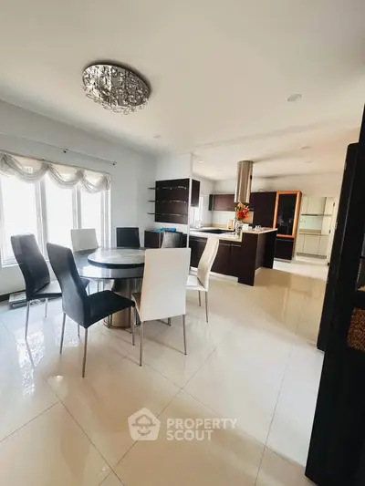 Spacious modern kitchen with dining area, sleek cabinetry, and elegant lighting, perfect for entertaining.