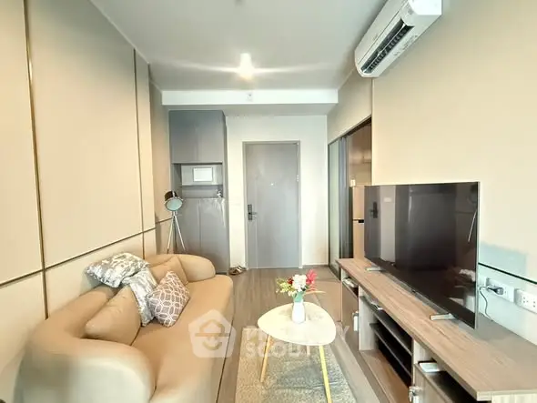 Modern living room with cozy sofa and flat-screen TV, perfect for relaxation.