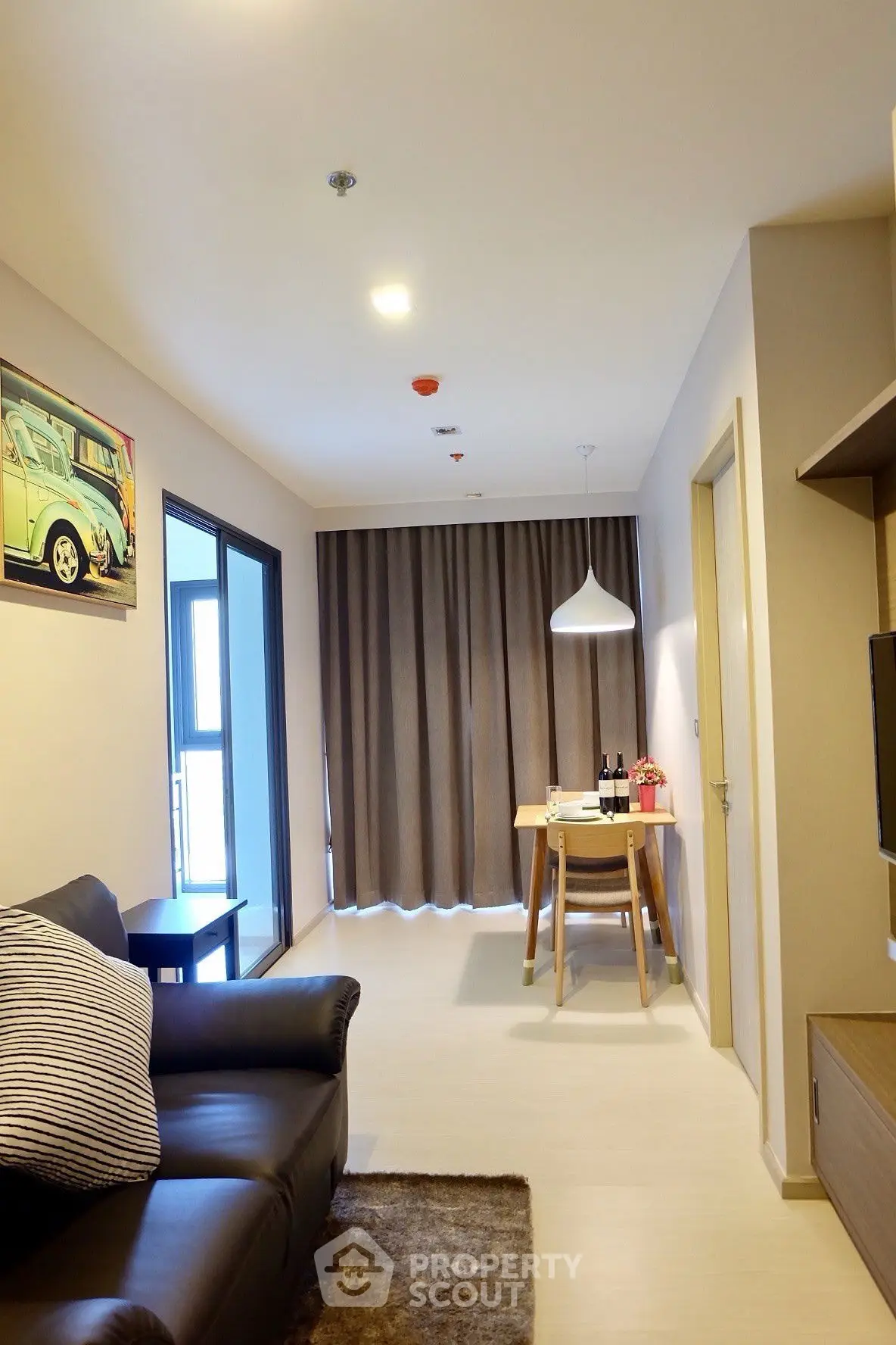 Modern living room with cozy seating and dining area, featuring stylish decor and natural light.