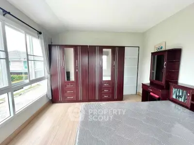 Spacious bedroom with large windows and elegant wooden furniture