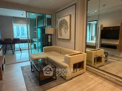 Modern living room with beige sofa, glass coffee table, and mirrored wall in a stylish apartment.