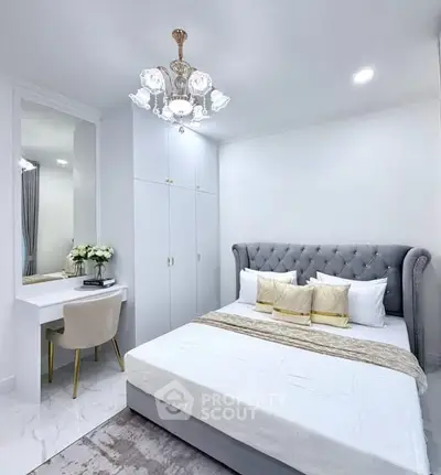 Elegant bedroom with plush bed, stylish chandelier, and cozy decor