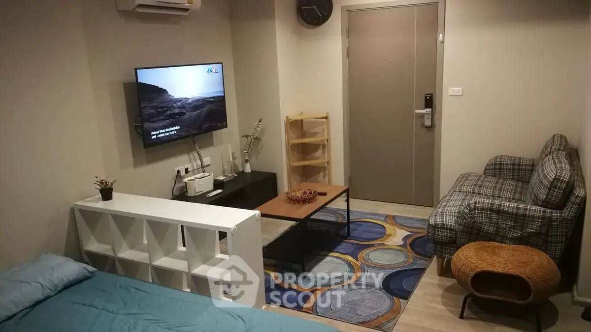 Cozy living room with modern decor and wall-mounted TV in a compact apartment.