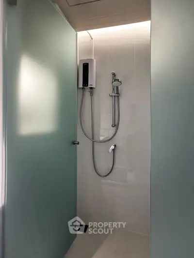 Modern bathroom shower area with sleek design and frosted glass door