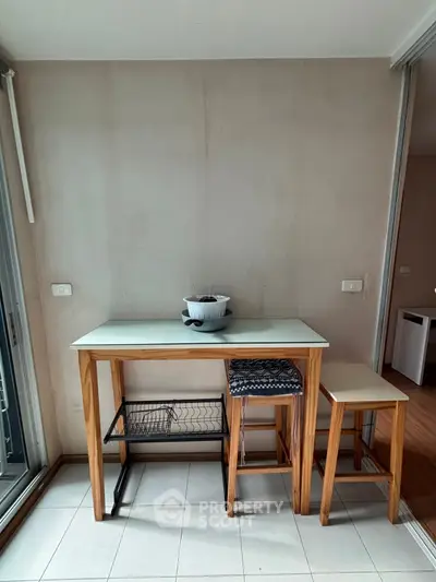Cozy kitchen corner with wooden table and stools, perfect for casual dining or morning coffee.