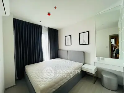 Modern bedroom with stylish decor and natural light, featuring a comfortable bed and elegant furnishings.
