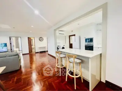 Spacious open-plan living room with modern kitchen and hardwood floors