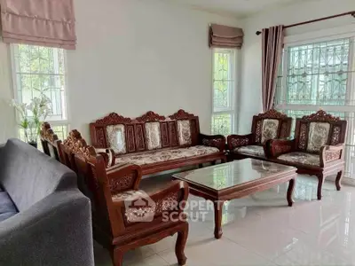 Elegant living room with ornate wooden furniture and large windows, perfect for relaxation and entertaining.