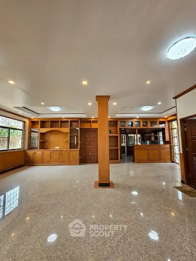 Spacious living room with elegant wooden cabinetry and polished flooring, perfect for modern living.
