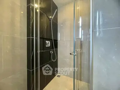 Modern bathroom with sleek glass shower enclosure and elegant tile design.