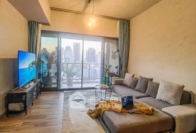 Spacious living room with modern decor and city view balcony, perfect for urban living.