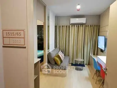 Modern living room with cozy seating and wall-mounted TV in stylish apartment.