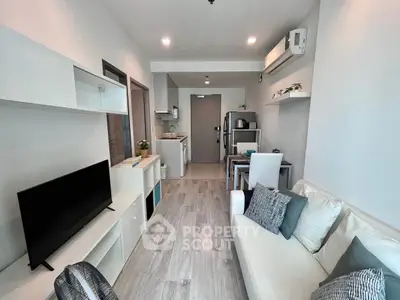 Modern living room with open kitchen in a stylish apartment, featuring sleek furniture and contemporary design.