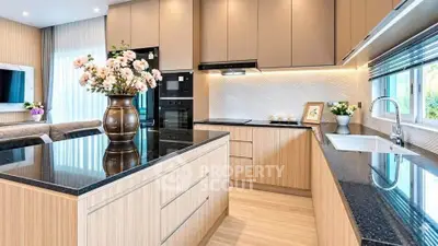 Modern kitchen with sleek cabinetry and black countertops in open layout design.