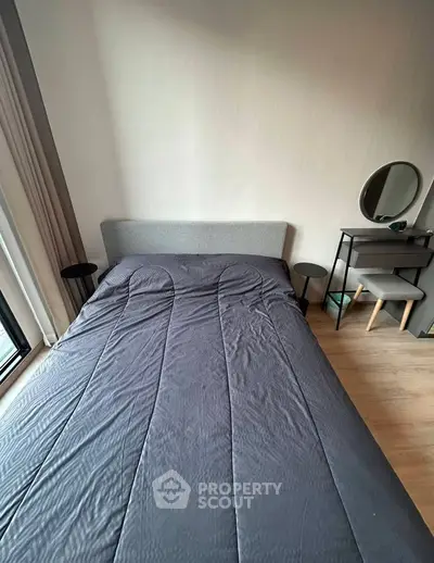Modern bedroom with stylish decor and natural light, featuring a cozy bed and sleek furniture.