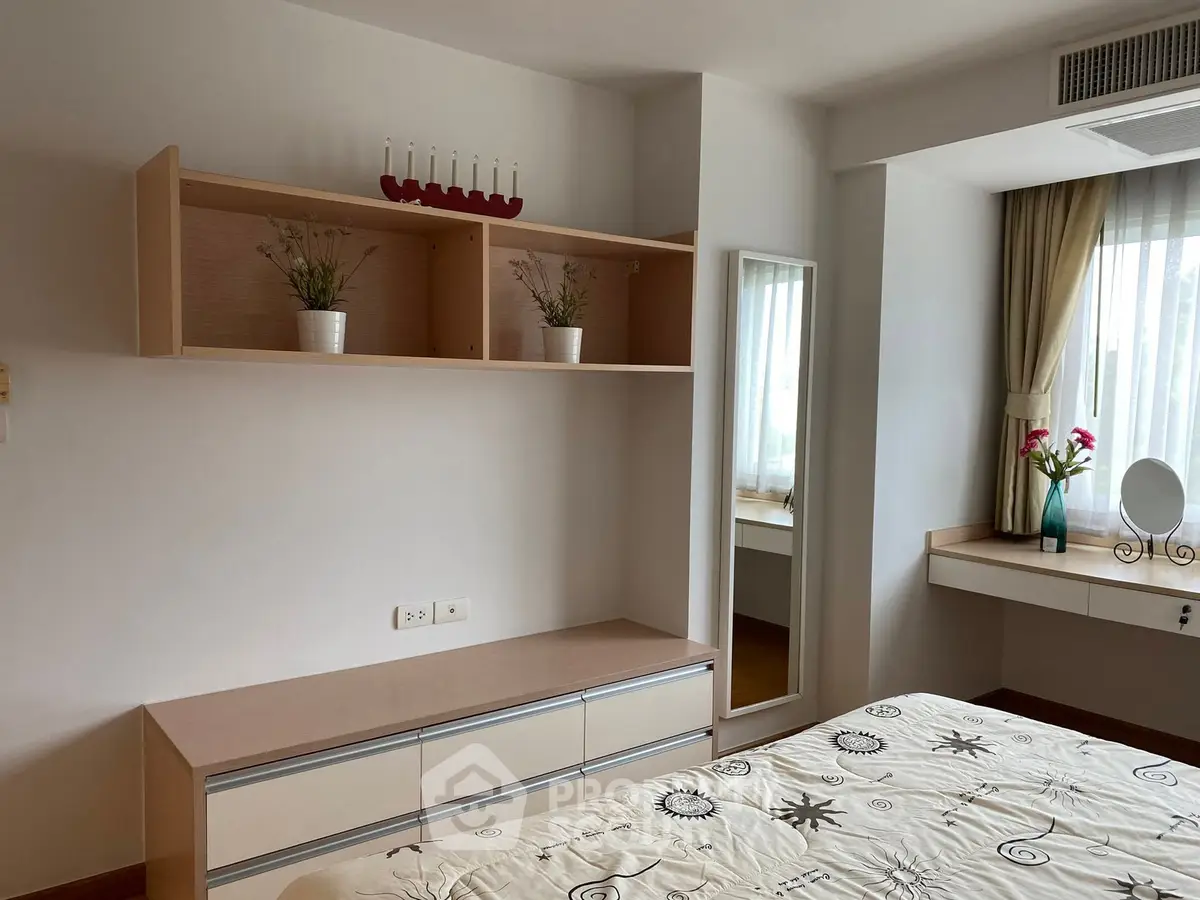Cozy bedroom with modern decor, featuring built-in shelves and a stylish vanity area.