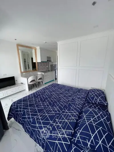 Modern bedroom with stylish decor and open kitchen layout in a contemporary apartment.