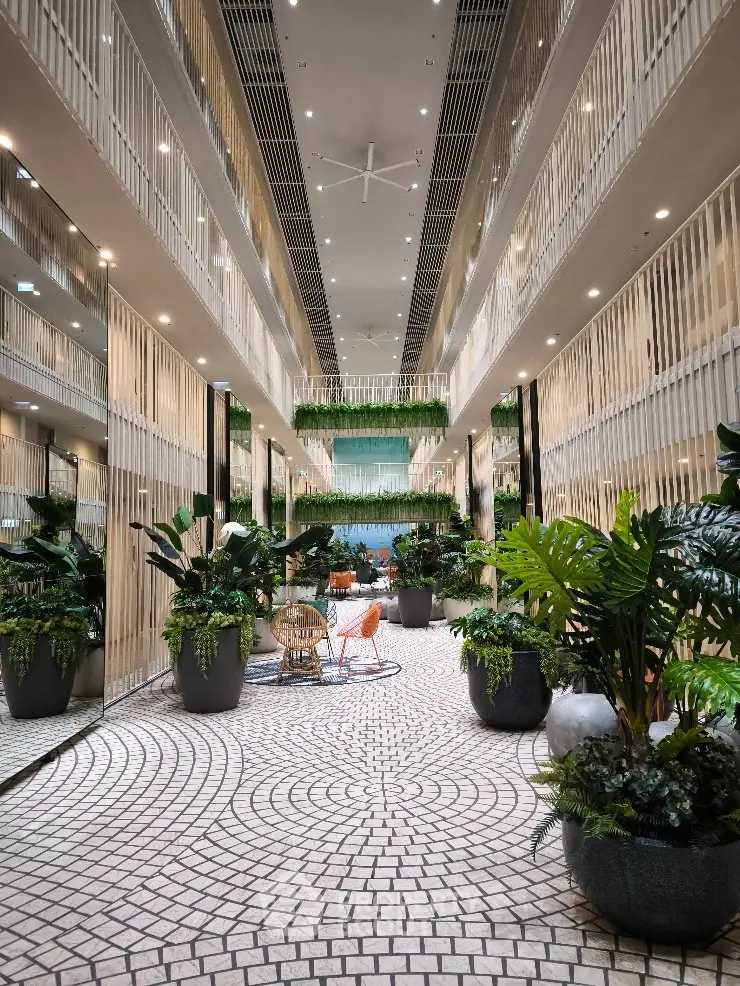Luxurious modern building interior with lush greenery and stylish seating area.