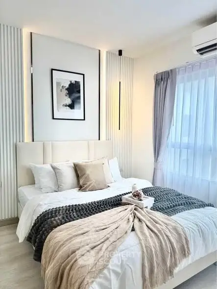 Elegant bedroom with modern decor and cozy bedding in a bright, airy space.