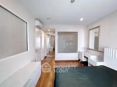 Spacious modern bedroom with hardwood floors and stylish decor
