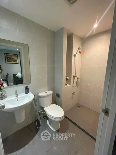 Modern bathroom with sleek fixtures and walk-in shower in a contemporary apartment.