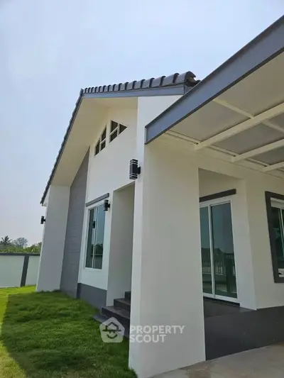 Modern minimalist house exterior with sleek design and lush green lawn