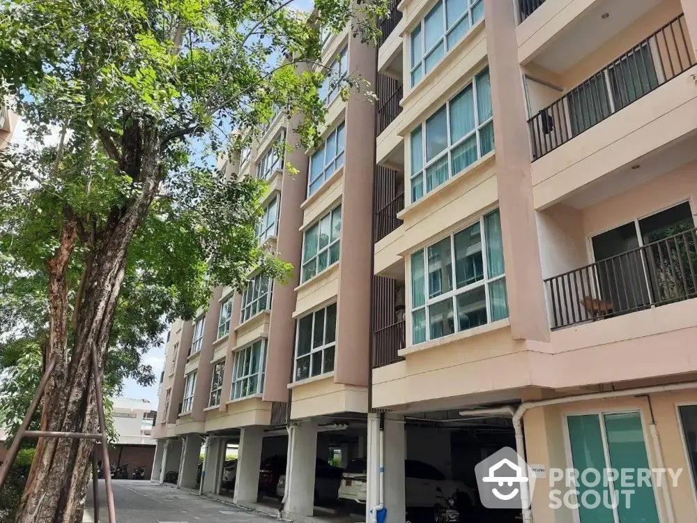 Modern apartment building with spacious balconies and lush greenery