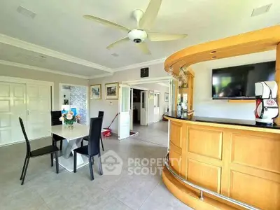 Spacious living room with modern bar and dining area, featuring elegant decor and ample natural light.