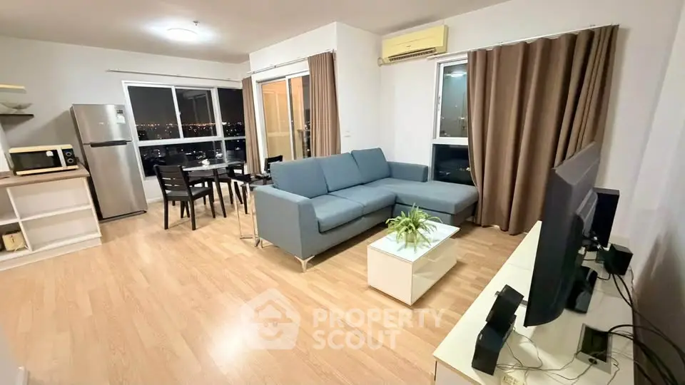 Modern open-layout living room with city view, featuring sleek furniture and stylish decor.