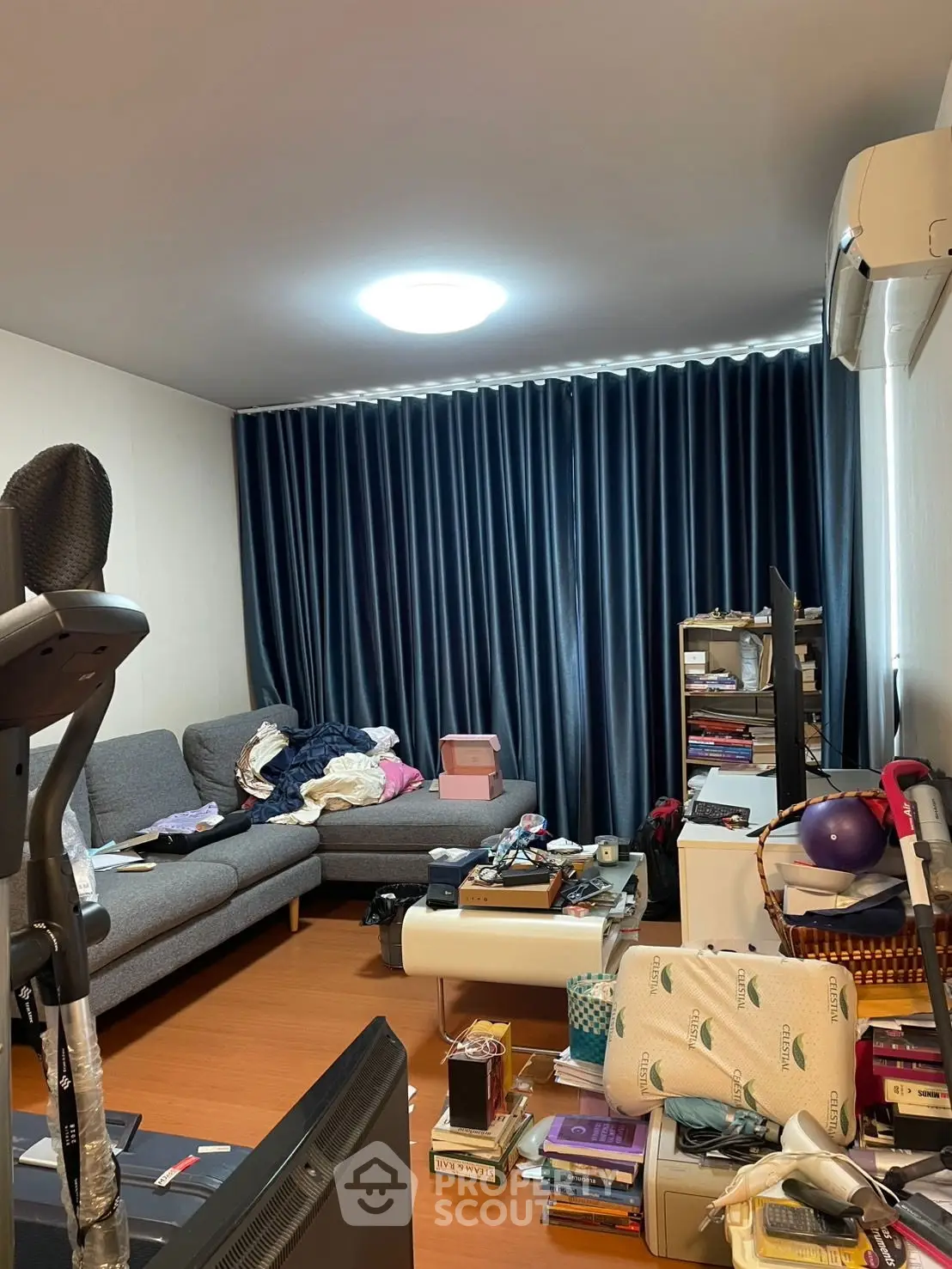 Spacious living room with modern sofa and exercise equipment, ideal for relaxation and fitness.