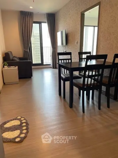 Modern living room with dining area and balcony view in stylish apartment.