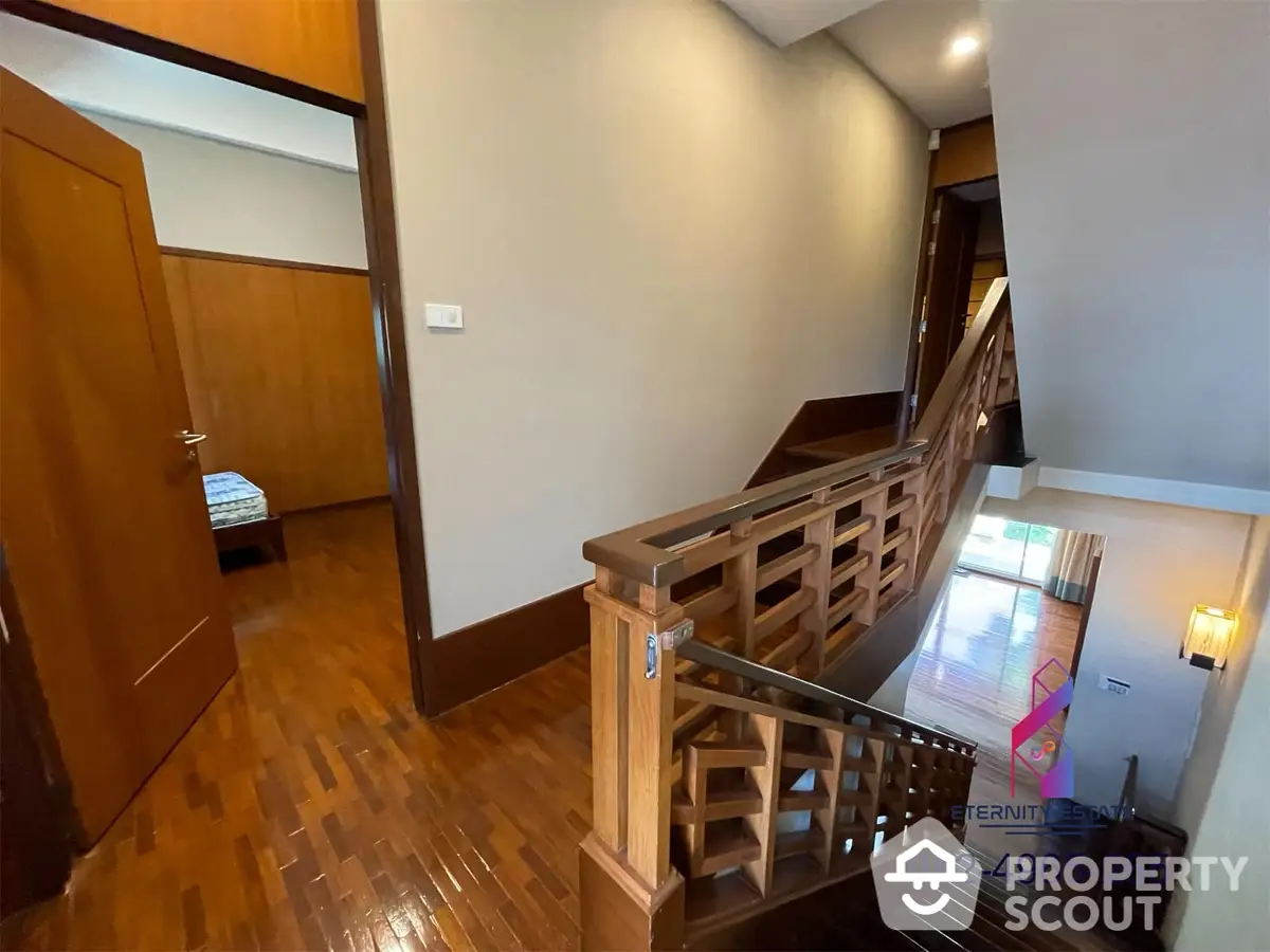 Elegant wooden staircase in a well-lit interior space with polished hardwood floors, leading to a cozy upper level, showcasing the home's vertical space and craftsmanship.