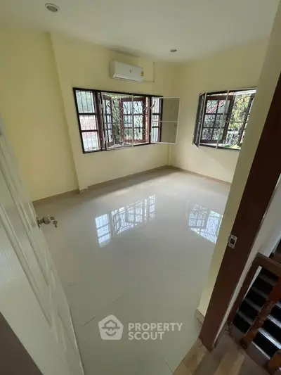 Bright empty room with large windows and air conditioning, perfect for customization.