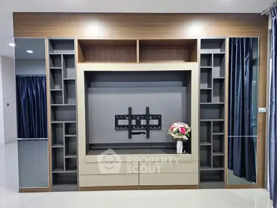 Modern living room with built-in entertainment center and elegant decor