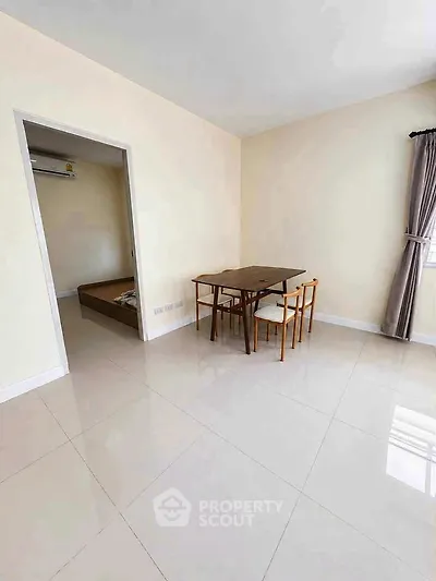 Spacious minimalist living area with dining set and natural light