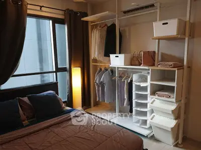 Cozy bedroom with modern open closet and large window for natural light.