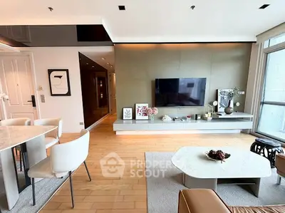 Modern living room with stylish decor and open layout, featuring a wall-mounted TV and elegant furniture.