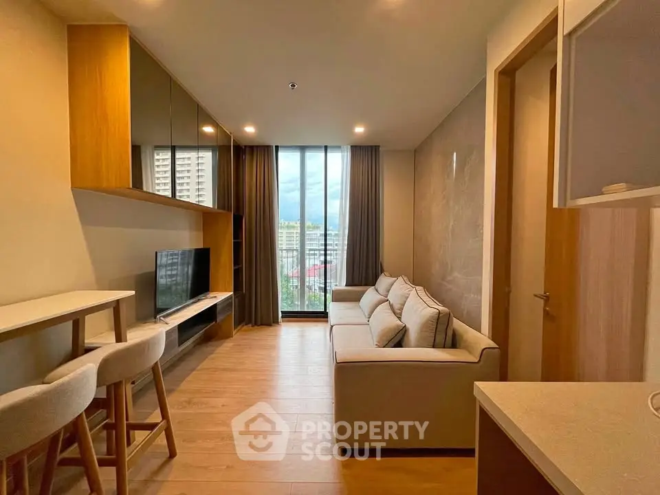Modern living room with stylish decor and large window offering a stunning city view.