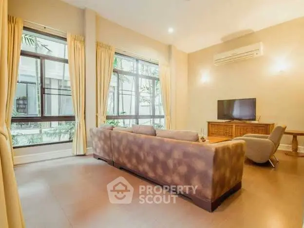 Spacious living room with large windows and modern furniture