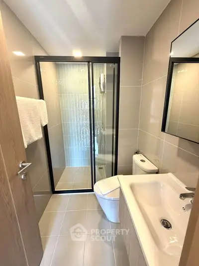 Modern bathroom with sleek shower and elegant fixtures in a contemporary apartment.